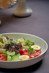 Bowl with salmon, quinoa and avocado on a blue background