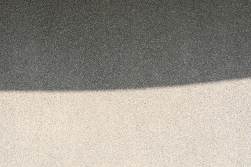 Abstract background from shadow on gravel wall.