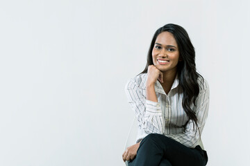 Young Indian woman sitting on a chair.