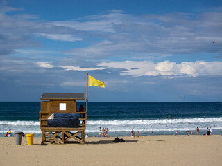 Panoramic view of Gross beach and on one side the lifeguard hut with a yellow flag waving and in...