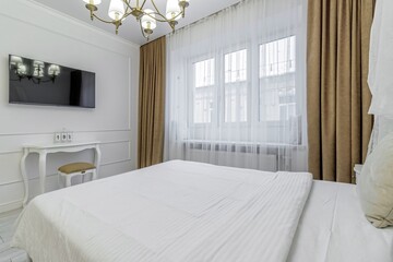 Interior in light colors with a bio fireplace, illuminated by burning sconces on the wall