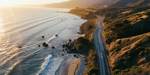 A highway running beside a peaceful beach, with waves gently lapping the shore as the sun rises - obrazy, fototapety, plakaty