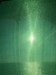 Closeup green shade net fabric pattern (Slant) for sunlight protection in construction site and...