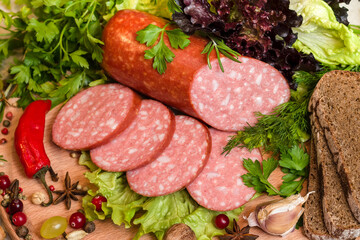 Top view of smoked sausage with seasonings, vegetables and slices of bread