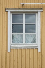 White framed window on yellow painted wooden wall.