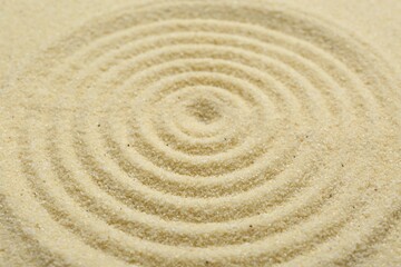 Fototapeta na wymiar Zen rock garden. Circle pattern on beige sand, closeup