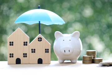 Protection, Model house under the umbrella and piggy bank on natural green background, Finance...