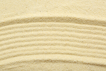 Zen rock garden. Wave pattern on beige sand, top view