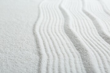Fototapeta na wymiar Zen rock garden. Wave pattern on white sand, closeup