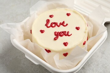 Bento cake with Love You text in takeaway box on light grey table, closeup. St. Valentine's day surprise