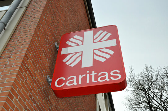 Caritas: Werbung am Haus der Caritas mit Logo und Schrift.
