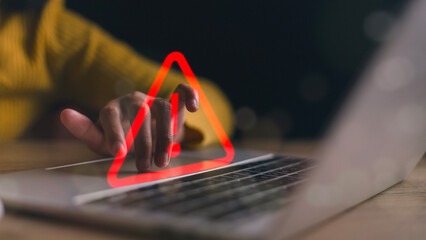 Business investment risks. Businesswoman use laptops with virtual warning signs for caution in...