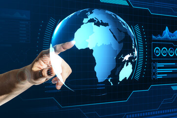 Close up of male hand pointing at holographic screen with digital globe interface and business chart on blurry blue background. HUD, international stock and future monitor concept.