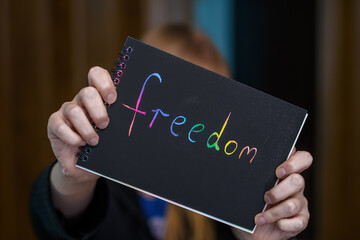 Napis na kartce wolność trzymany w dłoniach, freedom