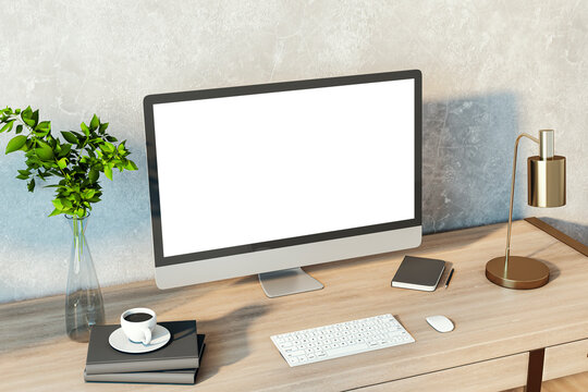 Creative designer desktop with empty white computer monitor, lamp, supplies and other items. Concrete wall background. Mock up, 3D Rendering.