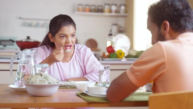 shoulder shot, happy joyful couples eating lunch by talking together at home on dining table - concept of communication, relationship conversation and married life
