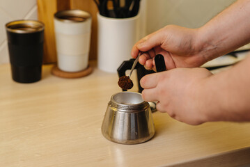 putting ground aromatic coffee into a geyser coffee maker for making espresso at home