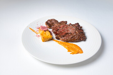 Grilled fresh veal entrecôte fillet with romesco sauce, potato with Himalayan salt; Isolated on white background.