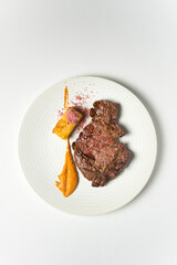 Grilled fresh veal entrecôte fillet with romesco sauce; potato with Himalayan salt, isolated on white background, top view.