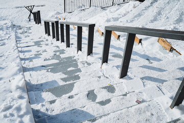 Snow-covered black metal outdoor staircase leading to building entrance