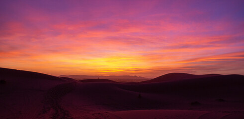 Vibrant sunrise over a scenic desert with dunes