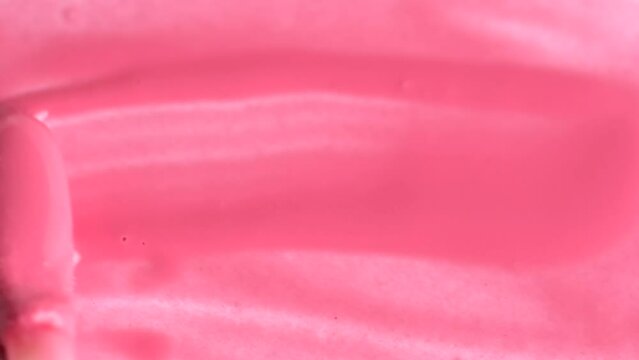 Pink lipgloss background. Swatch lip gloss, slow motion