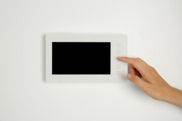 Fototapeta premium Woman using modern video intercom indoors, closeup