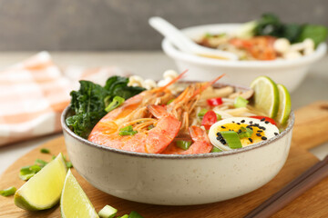 Delicious ramen with shrimps and egg in bowl on table, closeup. Noodle soup