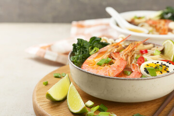 Delicious ramen with shrimps and egg in bowl on light textured table, space for text. Noodle soup