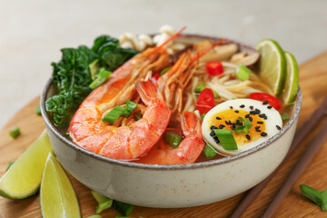 Delicious ramen with shrimps and egg in bowl on table, closeup. Noodle soup