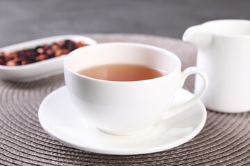 Aromatic tea in cup and saucer on table, closeup