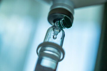 Close up medical intravenous IV drip in hospital background