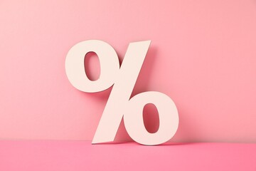 White wooden percent sign on pink background