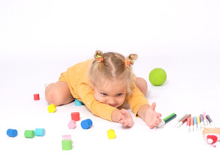 Adorable little girl plays among toys