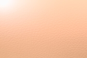Close up of peach fuzz leather gradient background. Light peach leather texture. Trend color year...