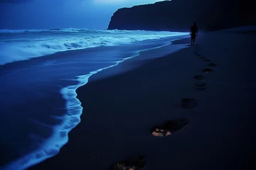 Rucksack person walking along shore, footprints glowing in sand © studioworkstock