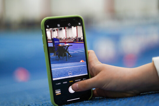 a child photographing an athletics track during a sports competition.
