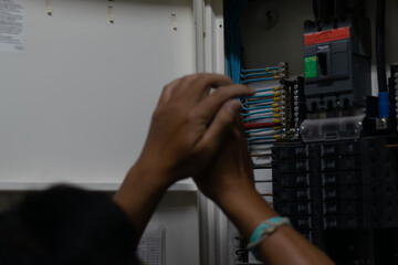 Electrician work tester measuring voltage and current of power electric line in electrical cabinet...