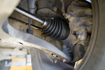 Closeup car's suspension system, focusing on the axle and CV joint area.