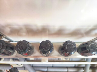 Close-up of plastic taps, valves, regulators on underfloor heating pipes and water standing in row