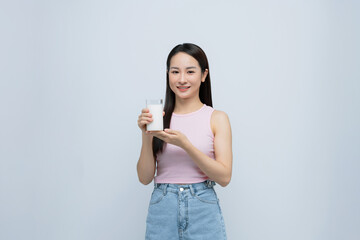 Healthy Asian woman drinking a glass of milk isolated on white background.
