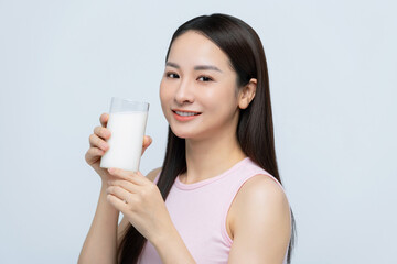 Portrait young asian woman drinking milk from the glass isolated over white background