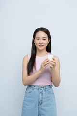 A satisfied young asian woman drinking milk from the glass isolated over white background