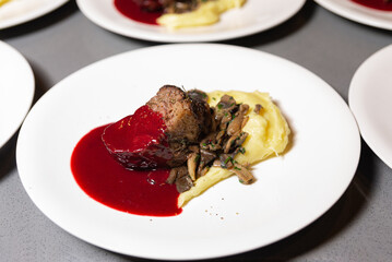 Gourmet Filet Mignon with Red Wine Reduction. Succulent filet mignon steak with a vibrant red wine reduction, served alongside creamy mashed potatoes and sautéed mushrooms.