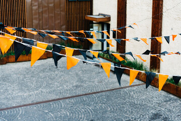 Halloween Bunting Flags in Street. Orange and black Halloween bunting flags strung across an...