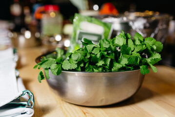 Fresh Coriander Leaves in Stainless Steel Bowl. A stainless steel bowl filled with vibrant green...
