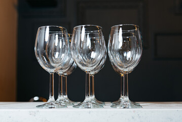 Elegant Empty Wine Glasses on Marble Counter. A set of four empty crystal wine glasses displayed on...