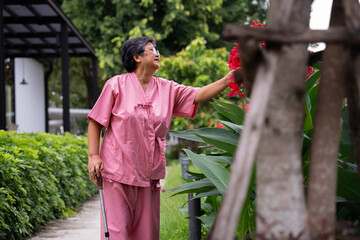 Retirement elderly old patient asian women use cane and walking in hospital outdoor park After rehabilitation and the illness has healed. healthy strong medical concept.