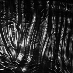 Plastic PNG Texture : Wrinkled black plastic bag texture on a black background, ideal for creative and decorative design purposes.