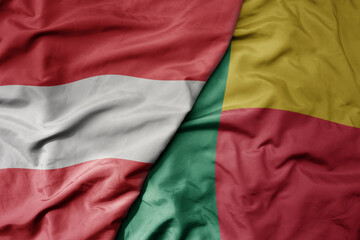 big waving national colorful flag of benin and national flag of austria .